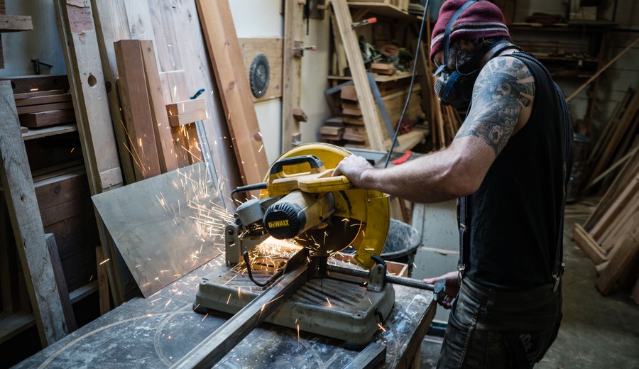 Man cutting metal in a workshop